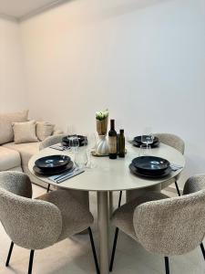 a white table with chairs and a white couch at APP Steps to the Sea 2026 in Funtana