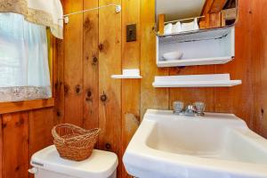 a bathroom with a white sink and a toilet at Water Views & Deck! Peaceful Northport Escape in Northport