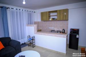 a living room with a counter and a kitchen at Mbaaria House, Meru in Meru