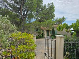 a gate in front of a house with trees at Le Castelas - Hébergement complet in Aurons