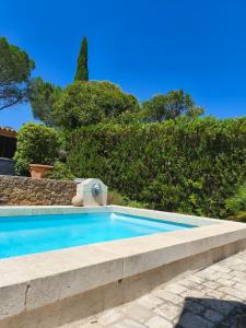 a swimming pool in a yard with trees at Le Castelas - Hébergement complet in Aurons