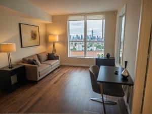 a living room with a couch and a table and a window at Premier Downtown Koreatown Apartment in Los Angeles