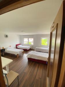 a room with two beds and a couch in it at Otoka Hostel in Sarajevo