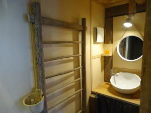 ein Bad mit einem Waschbecken und einem Spiegel in der Unterkunft Le ptit Tavalan in Seythenex