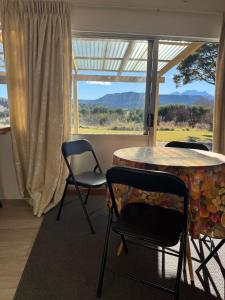 a room with a table and two chairs and a window at Awhina's Lodge in Ohakune
