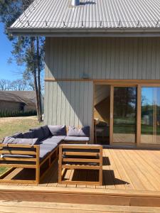 a couch sitting on a deck next to a house at Niva Rest in Pilica