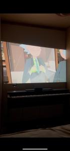 a television screen with a picture of a person on it at Niva Rest in Pilica +14 photos