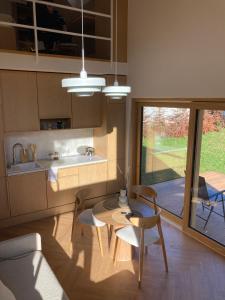 a living room with a table and chairs and a kitchen at Niva Rest in Pilica