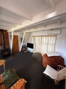 a room with two beds and a couch and a television at Awhina's Lodge in Ohakune
