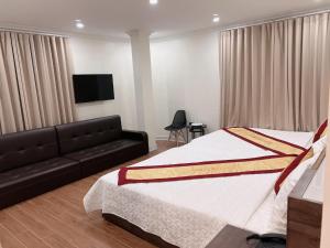 a bedroom with a bed and a couch at Phú Điền Motel in Ðại Sơn