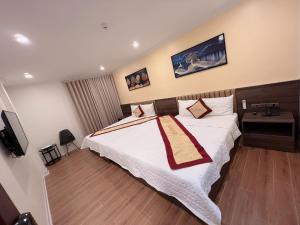 a bedroom with a large bed and a television at Phú Điền Motel in Ðại Sơn