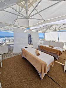 two beds under a white tent on a boat at Hotel Solitude in Riccione