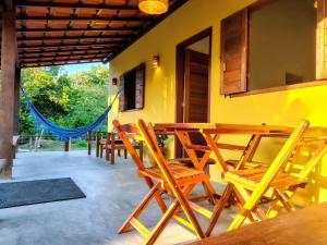 a patio with a wooden table and chairs at Casa Cajá - praia, natureza & conforto em Boipeba in Ilha de Boipeba