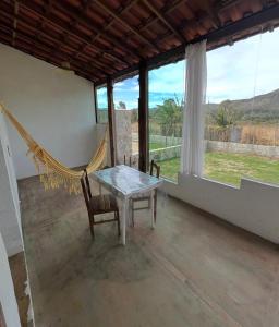a room with a hammock and a table and chairs at Pouso do Elefante in Serra do Cipo