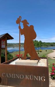 a statue of a woman holding a wand and a sign at Hostal Dobe in Benavides