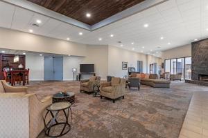 a lobby with couches and chairs and a television at Best Western Plus Madison-Huntsville Hotel in Madison