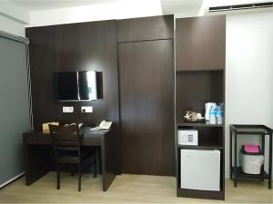 a room with a desk with a chair and a television at 7 Hotel in Juru