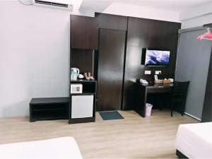 a room with a table and a desk with a computer at 7 Hotel in Juru