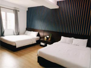 two beds in a hotel room with two beds sidx sidx sidx at 7 Hotel in Juru