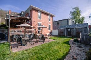 a patio with tables and chairs and umbrellas at Old Clark Inn in Marlinton
