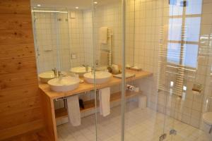 a bathroom with three sinks and a shower at Hôtel-Restaurant Mélèze Grimentz in Grimentz