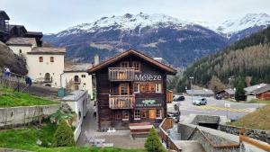 a building with a sign on it in a mountain at Hôtel-Restaurant Mélèze Grimentz in Grimentz
