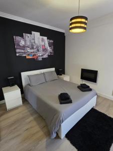 a bedroom with a large bed and a black wall at Apartamento para 6 hóspedes em Queluz próximo Lisboa,Sintra e Cascais in Queluz