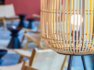 a close up of a lamp in a room with chairs at ibis Styles Bayreuth in Bayreuth