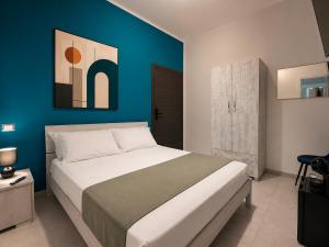 a bedroom with a large bed with a blue wall at The Arco Rooms in Pomigliano dʼArco
