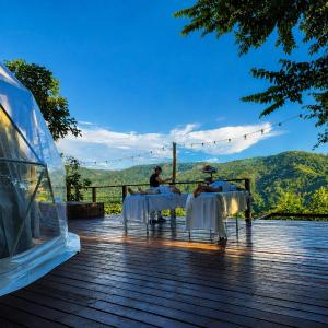 a couple of people sitting at tables on a deck at Shapaja Glamping in Tarapoto