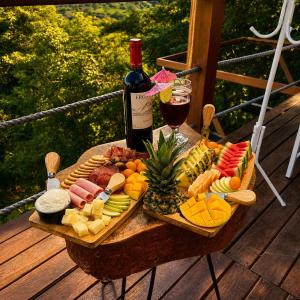 a table with a bunch of food and a bottle of wine at Shapaja Glamping in Tarapoto