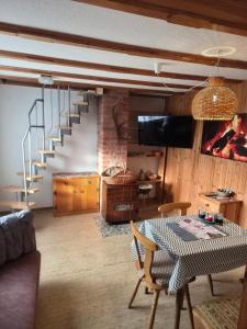 a living room with a table and a staircase at Idylissches Ferienhäusle im Thüringer Wald in Suhl