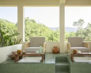 a room with two chairs and tables and windows at Angelique's Boutique Spa & Suites in La Unión
