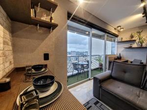 a living room with a couch and a table with plates at The Cittyplex Home Osasco Estilo & Conforto in Osasco
