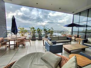 a living room with a balcony with tables and chairs at The Cittyplex Home Osasco Estilo & Conforto in Osasco