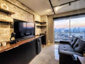 a living room with a large television and a couch at The Cittyplex Home Osasco Estilo & Conforto in Osasco