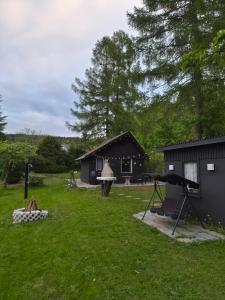 a house with a stage in a yard with a building at Idylissches Ferienhäusle im Thüringer Wald in Suhl
