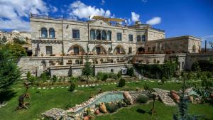 un gran edificio con un jardín delante de él en Goreme Inn Hotel Only Adult, en Göreme