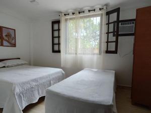 a bedroom with two beds and a window at Recanto dos sabias AP01 in Conservatória
