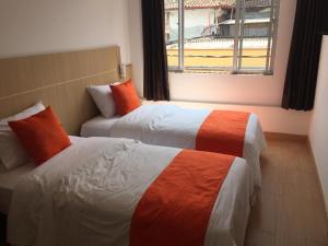 a hotel room with two beds and a window at Hotel Granada Plaza in Manizales