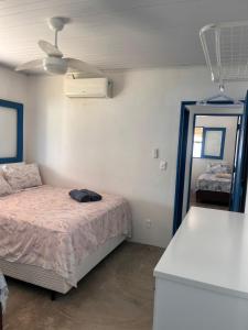 a small bedroom with a bed and a mirror at Califeira do Patacho in Pôrto de Pedras +32 photos