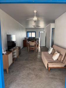 a living room with a couch and a dining room at Califeira do Patacho in Pôrto de Pedras
