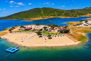 an island in the water with people on a beach at Bluemoon Campinho Rooftop & BBQ near Alqueva in Campinho