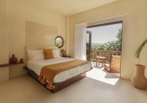 a bedroom with a bed and a balcony at Angelique's Boutique Spa & Suites in La Unión