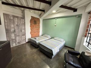 two beds in a room with a brick wall at La Curva in Cali