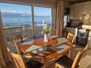 a dining room with a table and a large window at Ballyheigue Cliff Side and Sea View Apartment in Ballyheigue