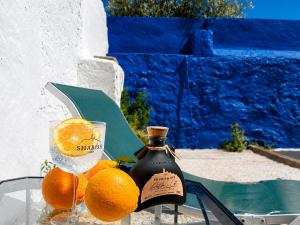 a bottle of wine and oranges on a table at Bluemoon Campinho Rooftop & BBQ near Alqueva in Campinho