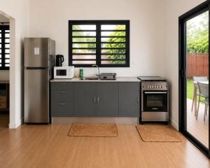 a kitchen with a stainless steel refrigerator and a stove at Au Petit Bungalow - Air conditionned & Mountain view in Moorea