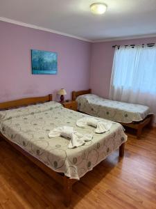 a bedroom with two beds with towels on them at Hotel Hielo Azul 1 in El Bolsón