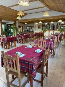 a restaurant with wooden tables and chairs with red and purple table cloth at Hotel Hielo Azul 1 in El Bolsón